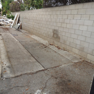 An alleyway filled with construction debris and junk, ready for removal by Vic's Haul Away & Junk Removal Service in Garden Grove, CA.