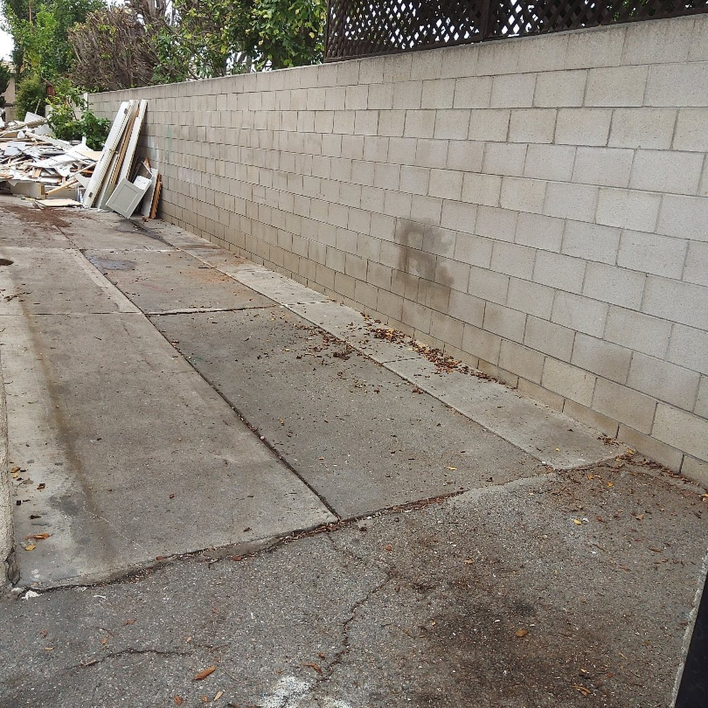 An alleyway filled with construction debris and junk, ready for removal by Vic's Haul Away & Junk Removal Service in Garden Grove, CA.