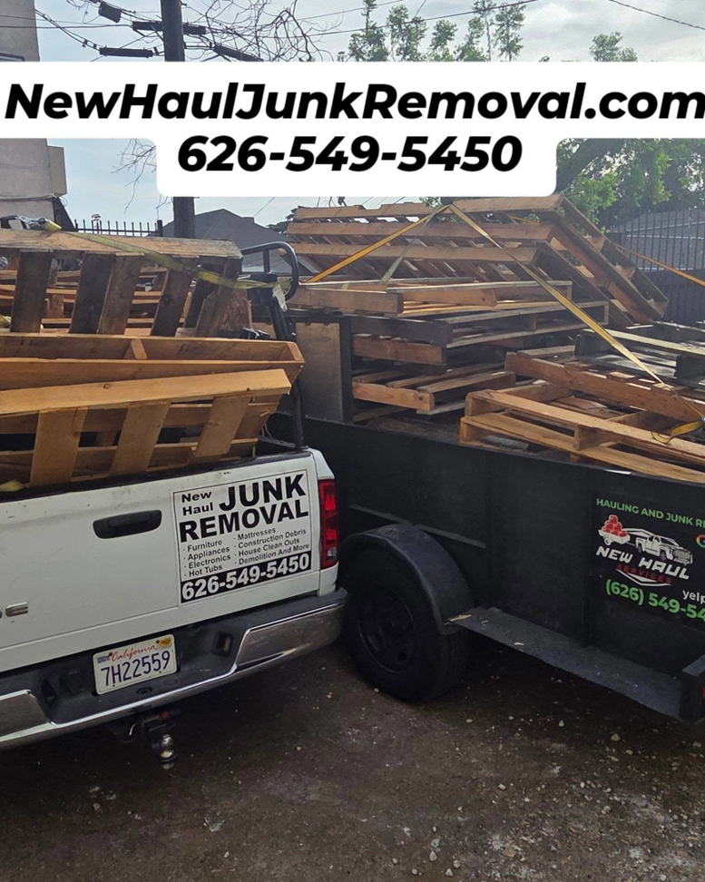 A New Haul Junk Removal truck and trailer loaded with wooden pallets for removal in South El Monte, CA.