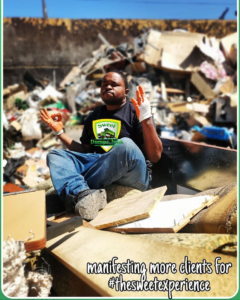 A Sweet Dumps Junk team member sits in a truck filled with removed junk, with a large pile of debris in Los Angeles, CA.