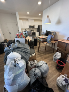 An apartment living area cluttered with bags of junk and household items, awaiting removal by Send It Hauling & Junk Removal LLC in Manteca, CA