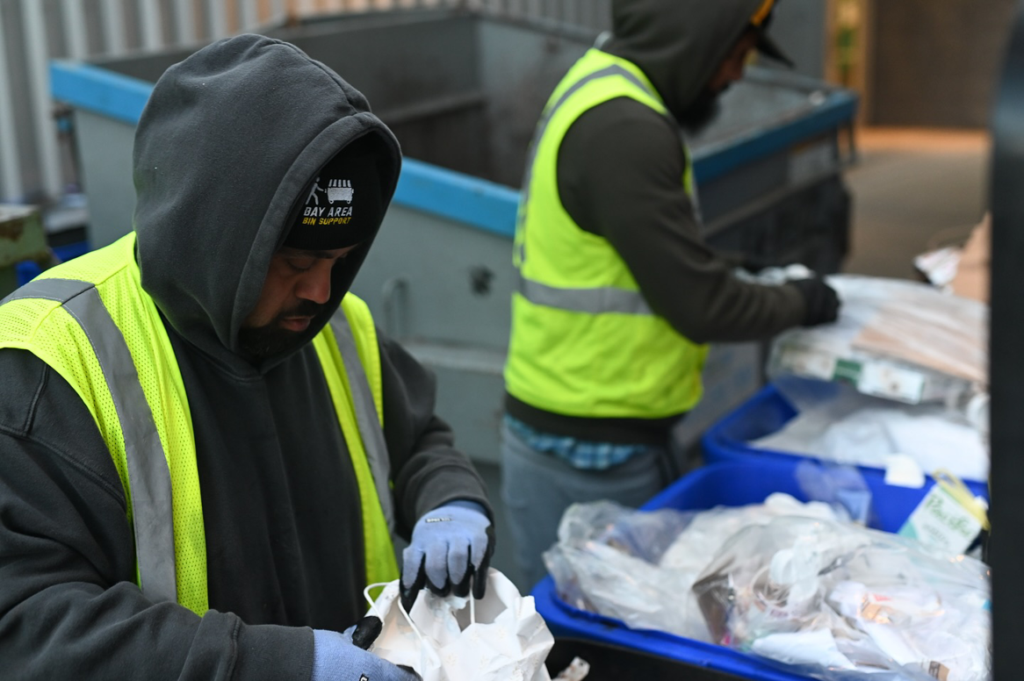A Bay Area Bin Support team member sorting waste into a bin, demonstrating general junk removal service in San Leandro, CA.