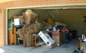 A cluttered garage filled with boxes, old furniture, and various items ready for junk removal by Harvey's Junk Hauling and Recycling LLC in Scottsdale, AZ.