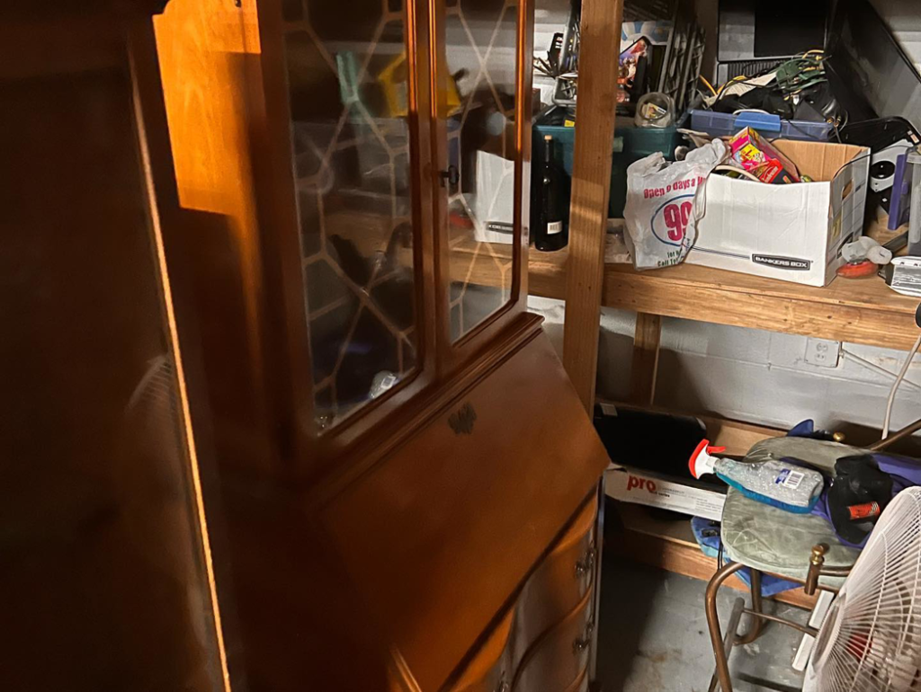 A cluttered garage with a wooden hutch and various items ready for general junk removal by Junk2Dump in Sacramento, CA.