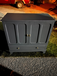 A dark blue wooden cabinet placed outdoors for general junk removal by Junk2Dump in Sacramento, CA.