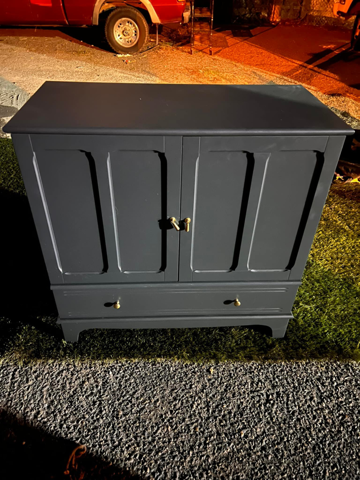 A dark blue wooden cabinet placed outdoors for general junk removal by Junk2Dump in Sacramento, CA.