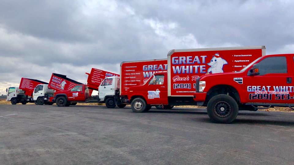 A fleet of red junk removal trucks ready for service from Great White Junk Removal in Stockton, CA