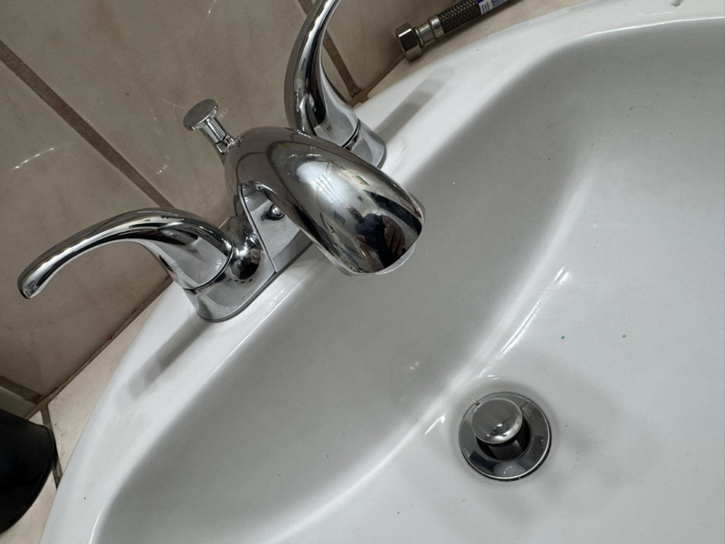 A newly installed chrome bathroom faucet and sink drain by Peraza Handyman Services Llc in Bakersfield, CA.