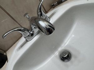 A newly installed chrome bathroom faucet and sink drain by Peraza Handyman Services Llc in Bakersfield, CA.