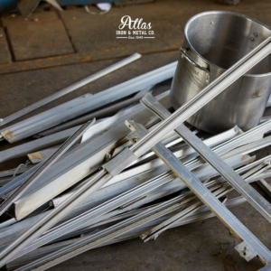 A pile of aluminum scrap metal and a metal bucket on the floor at Atlas Iron & Metal Co. in Los Angeles, CA