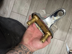 A plumber holding a new faucet assembly for installation by Peraza Handyman Services Llc in Bakersfield, CA.