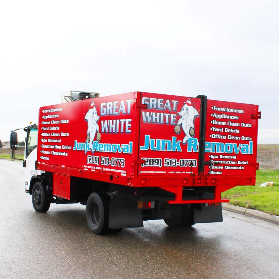 A red junk removal truck from Great White Junk Removal, showing the rear and services in Stockton, CA