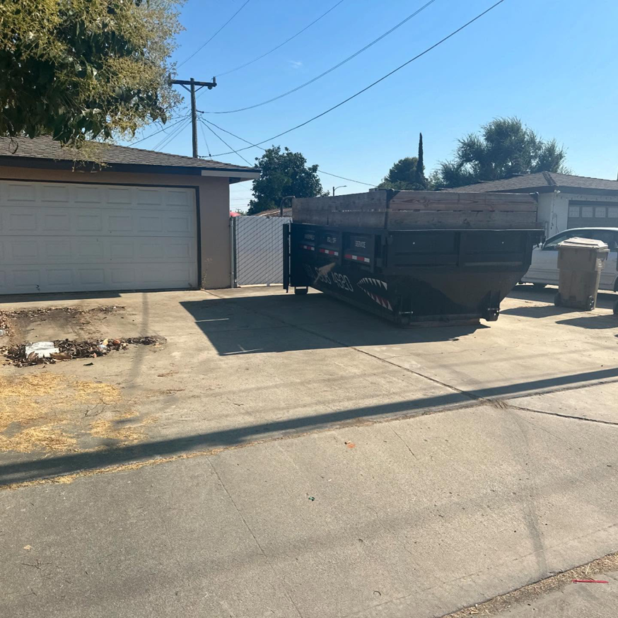 A roll-off dumpster placed for residential junk removal by Bakersfield Roll-Off Service in Bakersfield, CA.