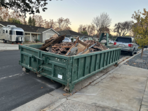 A West Coast Recycle dumpster filled with residential junk and debris on a street in San Jose, CA.