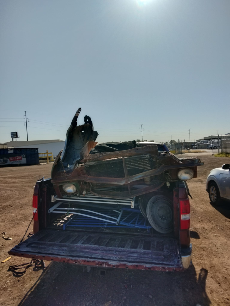 A pickup truck loaded with a car body and scrap metal for hauling by Harvey's Junk Hauling and Recycling LLC in Scottsdale, AZ.