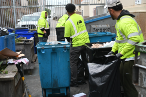 A Bay Area Bin Support team handling bins and trash bags during a general junk removal service in San Leandro, CA.