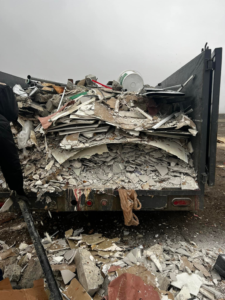 A heavy-duty trailer loaded with demolition debris and drywall pieces from a junk removal job by We Haul It All in Lakeland, FL