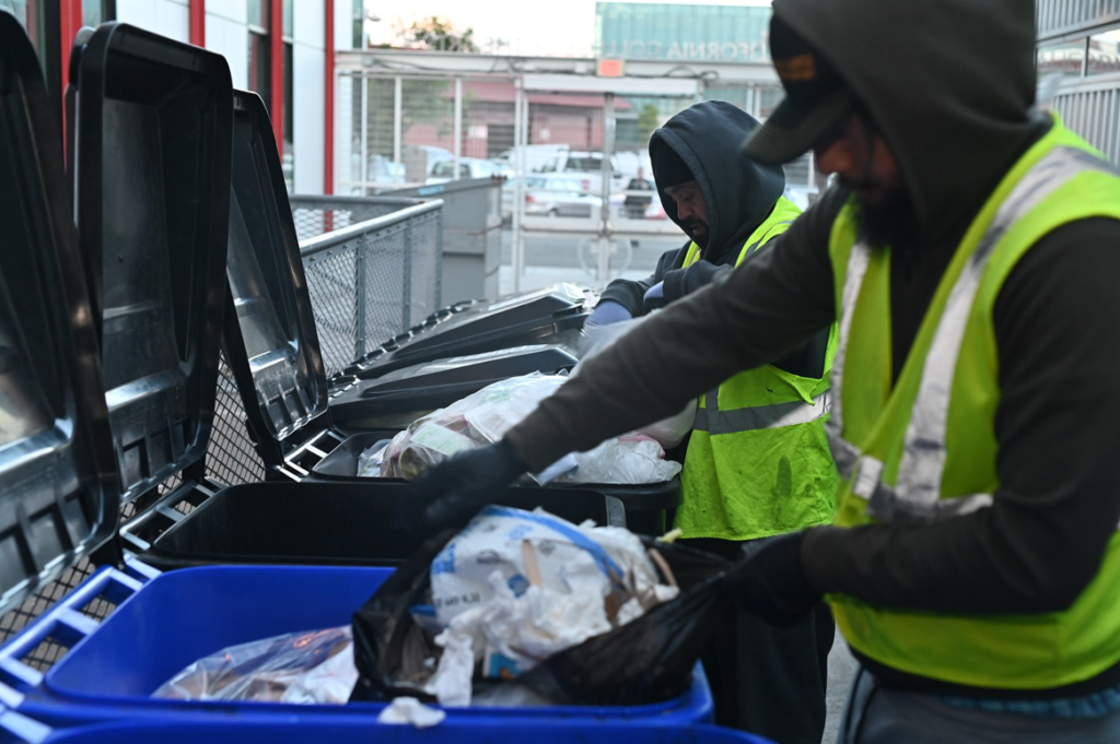 Two workers from Bay Area Bin Support sorting trash into bins during a general junk removal job in San Leandro, CA.